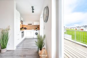 a kitchen with white cabinets and a balcony at Ferienwohnung Nicks Seestern Olpenitz in Olpenitz +36 photos