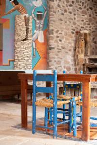 einem Holztisch mit einem blauen Stuhl neben einer Wand in der Unterkunft Cabaña Master Suite Riviera Caxcana in Apozol