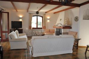 un soggiorno con mobili bianchi e una TV di Villa Annalia a Cannigione