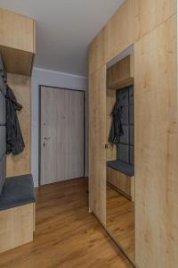 a room with a large wooden wall with a mirror at Glow Apartments, Apartamenty Nowa Letnica in Gdańsk