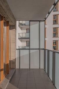an empty corridor in a building with glass doors at Glow Apartments, Apartamenty Nowa Letnica in Gdańsk