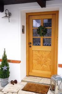 une porte en bois sur une maison avec un arbre de Noël dans l'établissement eleven Marquartstein, à Marquartstein