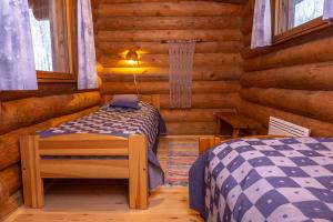 1 dormitorio con 2 camas en una cabaña de madera en Iltarusko, en Kuusamo