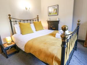 1 dormitorio con 1 cama grande con almohadas amarillas en The Old Sunday School, en Richmond