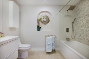 a bathroom with a toilet and a tub and a mirror at Naples Dream at WTC with Heated Pool SPA Sauna 7 bicycles and 3 mls to beach in Naples