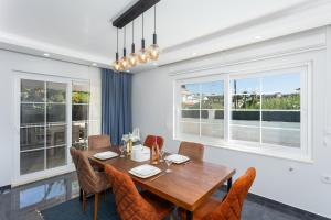 a dining room with a table and chairs and windows at Villa Capital in Dalyan