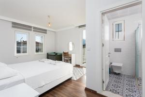 a white bedroom with a bed and a bathroom at Villa Capital in Dalyan