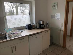 a kitchen with a counter with a sink and a window at Ferienhaus Ahrensmoor in Ahlerstedt