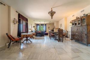ein großes Wohnzimmer mit einem Tisch und Stühlen in der Unterkunft Hacienda San Marcos in Baena
