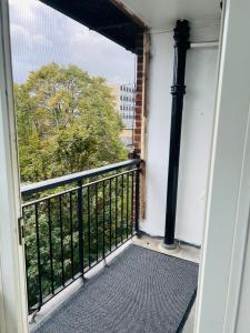 an open door to a balcony with a pole at Elegant Downtown Escape in London