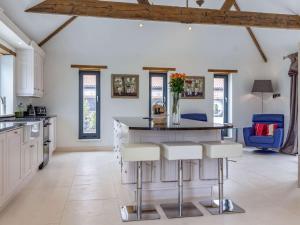 een keuken met witte kasten en een groot eiland met krukken bij 2 bed in Lound 82801 in Hopton on Sea