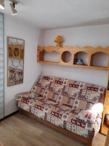 マニグードにあるAppartement au cœur des Aravisのベッドルーム1室(ベッド1台、壁に棚付)