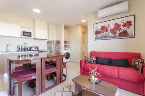een woonkamer met een rode bank en een tafel bij Luxurious Apartment With Two Bedrooms in Asuncion