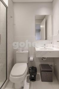 a bathroom with a toilet and a sink and a mirror at Luxurious Apartment With Two Bedrooms in Asuncion