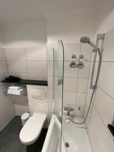 ein weißes Bad mit einer Dusche und einem WC in der Unterkunft SUITE APART direkt am Bahnhof in Eisenach