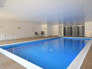 a large pool with blue water in a building at 2 Bed in Taunton KIBSH in Trull