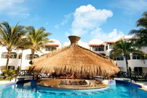um resort com um grande guarda-chuva de palha e uma piscina em Hidden Beach Resort Au Naturel Adults Only Catamarán, Cenote & More Inclusive em Akumal