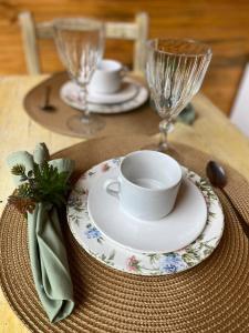 a table with a cup and a plate on a table at chalé Platanus in Campos do Jordão