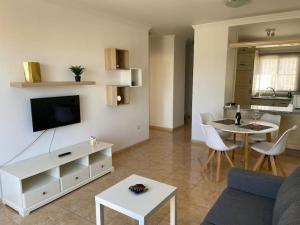 a living room with a couch and a tv and a table at Amazing Penthouse in Los Cristianos