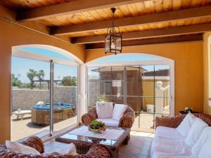 a living room with a couch and a table at Caleta de Fuste Villa Vergel with Huge Private Pool, Jacuzzi, & BBQ by Amazzzing Travel in Caleta De Fuste
