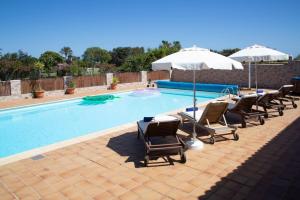カレタ・デ・フステにあるCaleta de Fuste Villa Vergel with Huge Private Pool, Jacuzzi, & BBQ by Amazzzing Travelのラウンジチェアとパラソル付きのスイミングプール