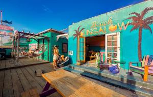 a woman standing in front of a colorful building at ITH Beach Bungalow Surf Hostel San Diego in San Diego