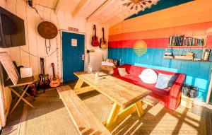 een woonkamer met een rode bank en een tafel bij ITH Beach Bungalow Surf Hostel San Diego in San Diego
