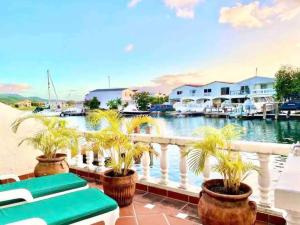 a balcony with palm trees inront of a marina at Two Bedroom Luxury Townhome Located In Jolly Harbour in Jolly Harbour