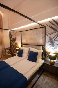 una camera con letto a baldacchino e cuscini blu di Urso Apartament Premium a Przemyśl