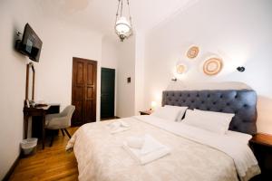 a bedroom with a large bed with a blue headboard at Ntouana hotel in Kalamata