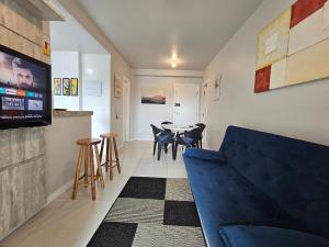a living room with a blue couch and a table at AP encantador na Praia do Forte! Porto Azul (106) in Cabo Frio
