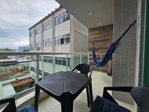 a balcony with a table and an umbrella on it at AP encantador na Praia do Forte! Porto Azul (106) in Cabo Frio