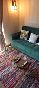 a living room with a green couch and a coffee table at Pura Vida Matos House in Fafião