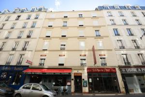 a large building with cars parked in front of it at HOTEL WATTIGNIES in Paris
