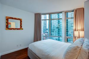 um quarto com uma cama e uma grande janela em Dunowen Properties em Vancouver