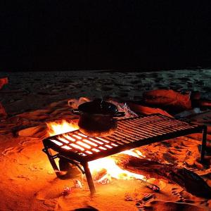 un pot au-dessus d'un feu de camp dans l'établissement White desert & Black desert camb, à Qasr Al Farafirah