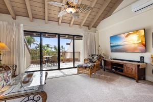 uma sala de estar com uma televisão de ecrã plano e um sofá em Maui Kamaole L209 - MCH em Kihei