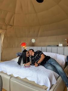 a man and a woman laying on a bed at Tres Lunas Domo in Mazamitla