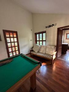 uma sala de estar com uma mesa de bilhar e um sofá em Recanto de Mairiporã em Mairiporã