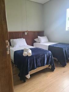 - 2 lits dans une chambre d'hôtel avec des serviettes dans l'établissement Casas de alto padrão em Condominio Privado, à Chapada dos Guimarães