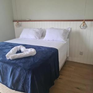 a bed with a white towel on top of it at Casas de alto padrão em Condominio Privado in Chapada dos Guimarães
