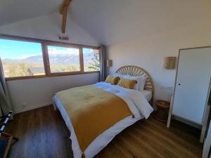 Schlafzimmer mit einem Bett und einem großen Fenster in der Unterkunft Appartement 4 personnes Lac d'Annecy in Lathuile