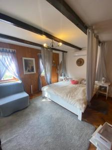a bedroom with a large bed and a blue couch at M&M Kuća za odmor in Vrbovec