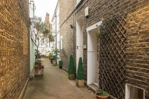 an alley with potted plants and a brick building at Superb Retreat Central Next Tube in London