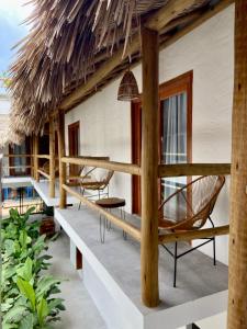 een resort met een terras met stoelen en een rieten dak bij Pousada Baobá in Jericoacoara