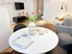uma mesa branca com um vaso branco com flores em Cozy and stylish flat close to Schoenbrunn Palace em Viena