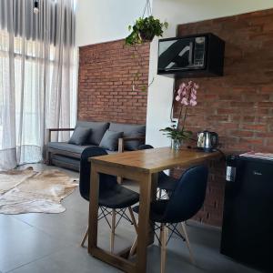 uma sala de estar com uma mesa de madeira e cadeiras em The Guest House hostel em Balneário Gaivotas