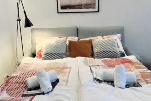 um quarto com 2 camas com lençóis brancos e almofadas em Cozy and stylish flat close to Schoenbrunn Palace em Viena