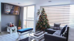 ein Wohnzimmer mit einem Weihnachtsbaum in der Ecke in der Unterkunft TOCANCIPÁ, Increíble, Hermoso y Moderno APARTAMENTO COMPLETO! in Tocancipá