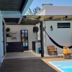 Balneário Gaivotas的住宿－The Guest House hostel，一个带吊床的庭院和一个游泳池